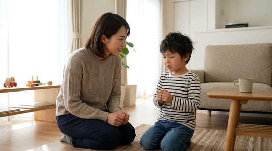 リビングの床に座った大人の女性が、向かい合って座る男の子の話をおだやかに聞いている様子