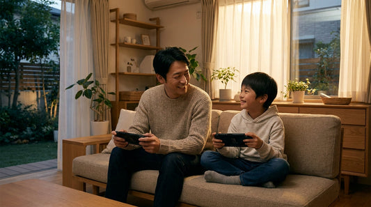 ソファに並んで座り、携帯ゲーム機を持って笑い合う大人の男性と男の子