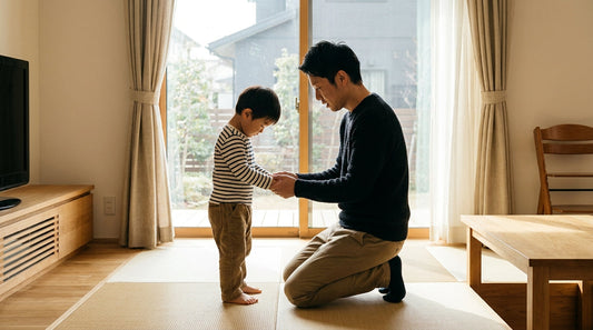 畳の部屋で、大人の男性がひざをついて男の子と向き合い、両手を取って話している